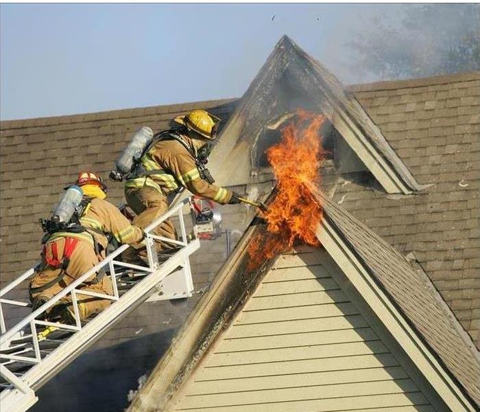 Firemen on ladder fighting 2nd story